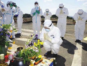 Impuissant devant l'ampleur de la catastrophe, le gouverneur de la province de Fukushima, Yuhei Sato, se recueille devant un autel improvisé.  Namie (préfecture de Fukushima), le 15 mai 2011.  Source image : MaxPPP